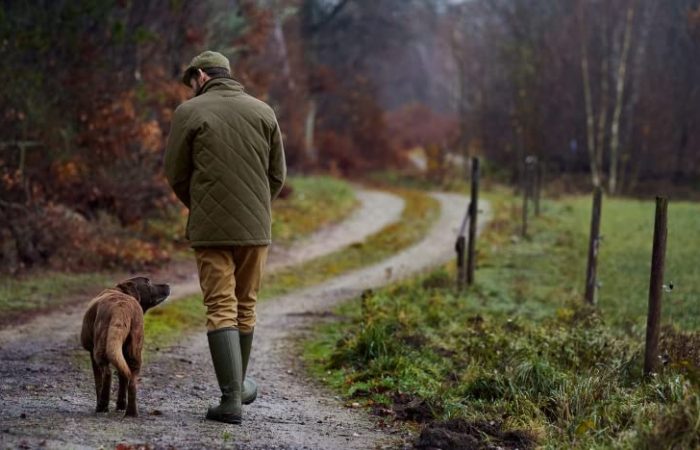 bushwear dog and man walking on country path