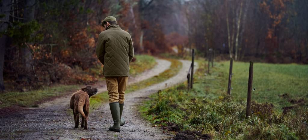 bushwear dog and man walking on country path
