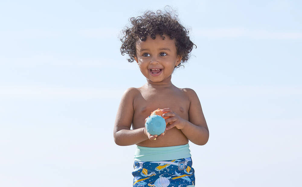 young child on the beach in splash about products