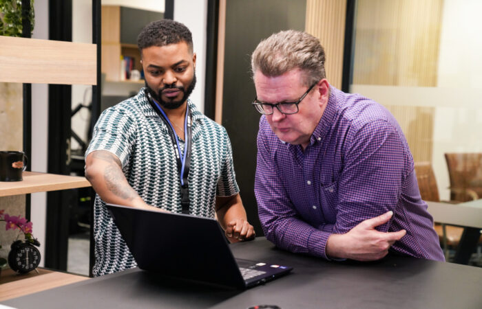 richard and theo (two men) looking at data on a laptop