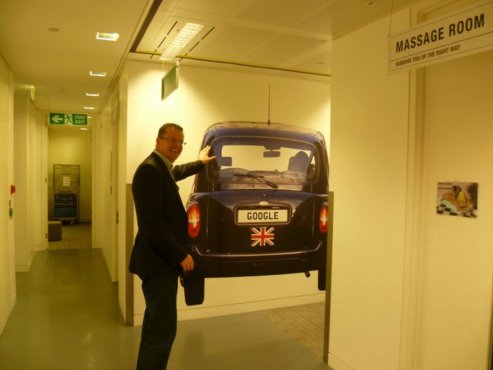 picture of richard hill at google offices standing in front of a picture of a car
