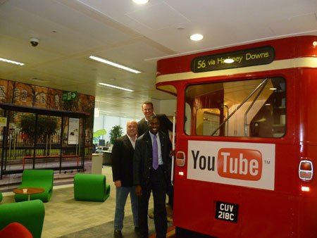 picture of andy and richard in front of a red bus that says youtube on it